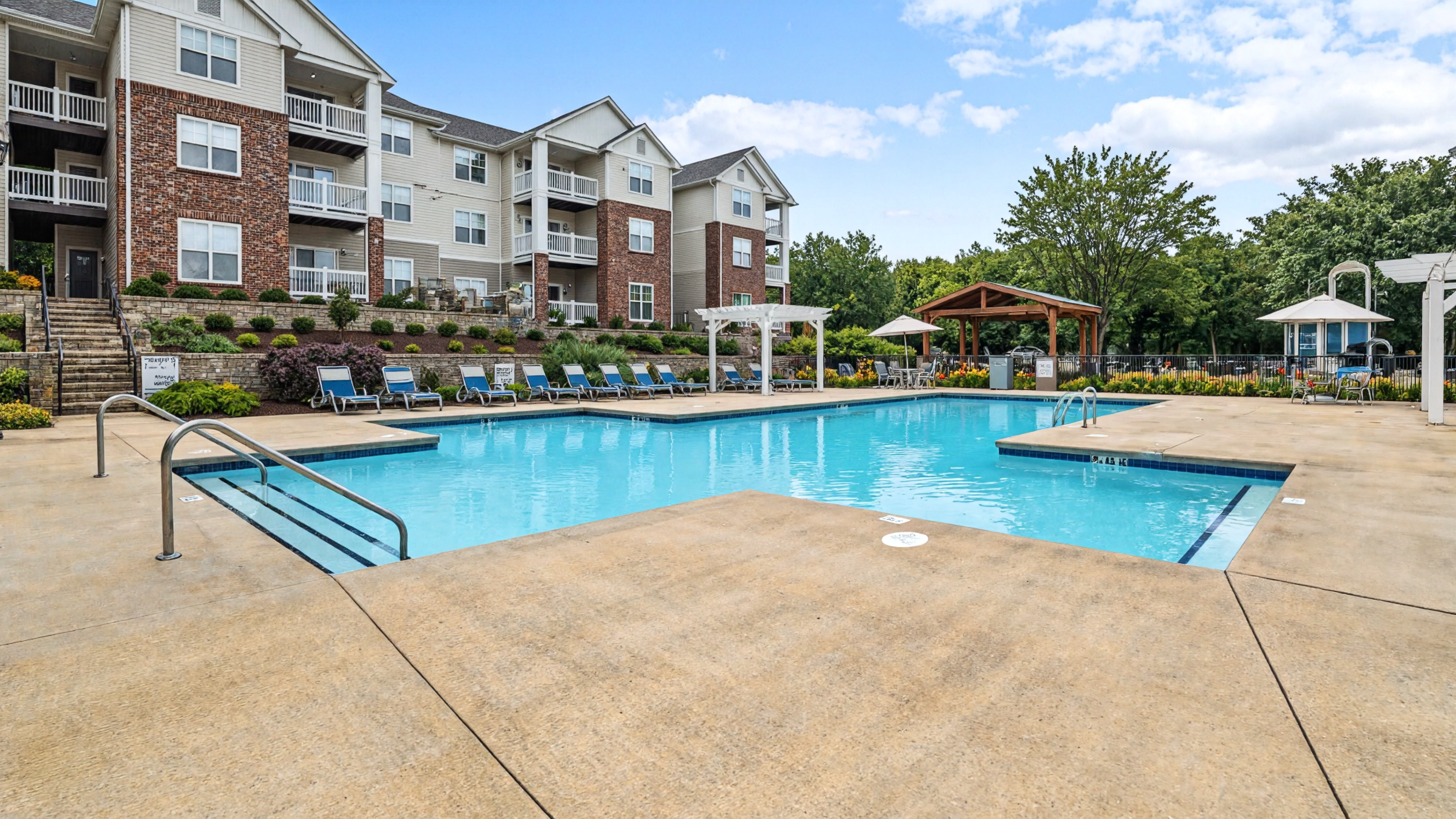 Hawthorne at Main large outdoor pool with surrounding seating, umbrellas, and grilling area