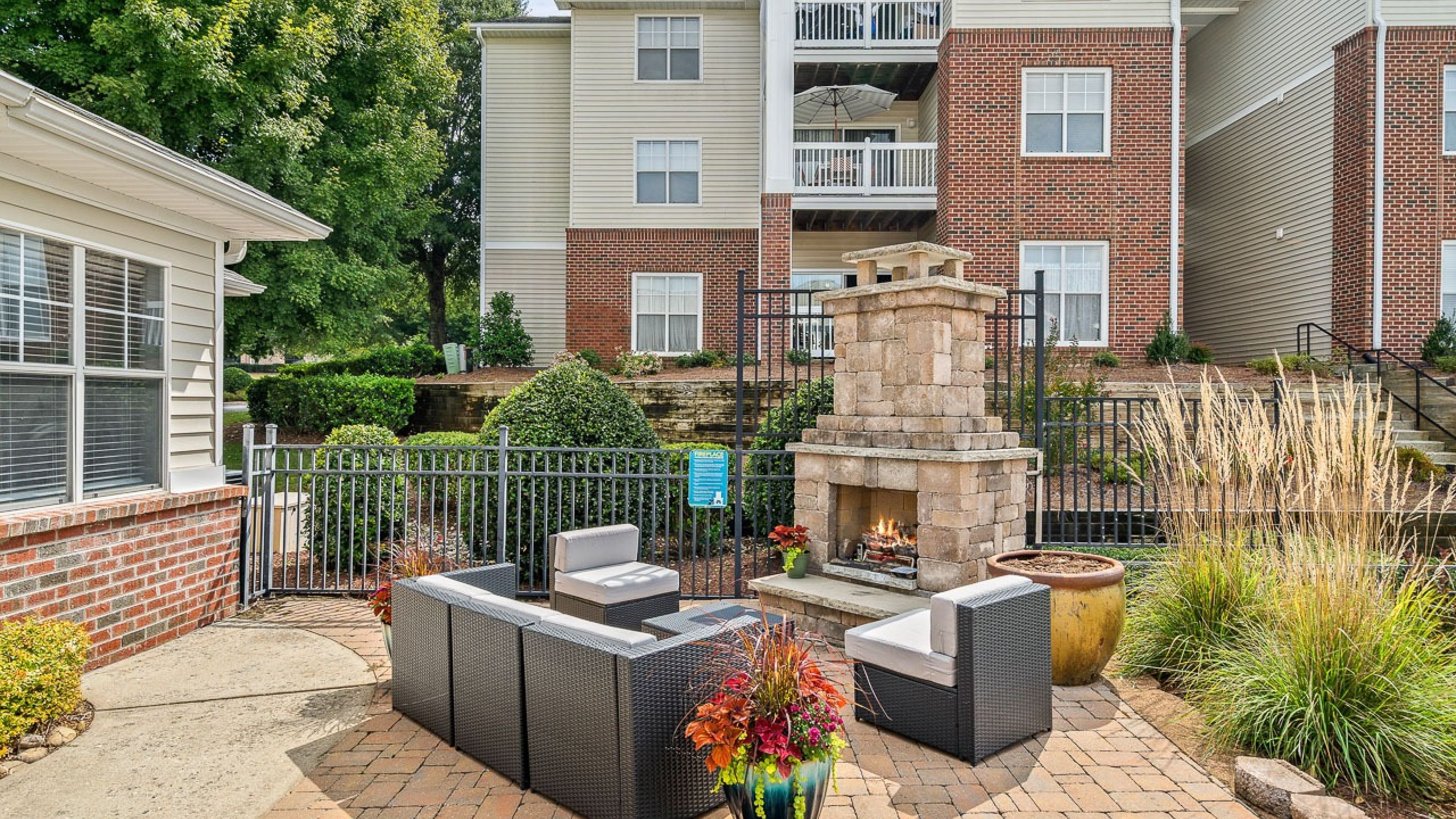 Hawthorne at Main apartments community exterior with outdoor fireplace lounge patio and landscaping