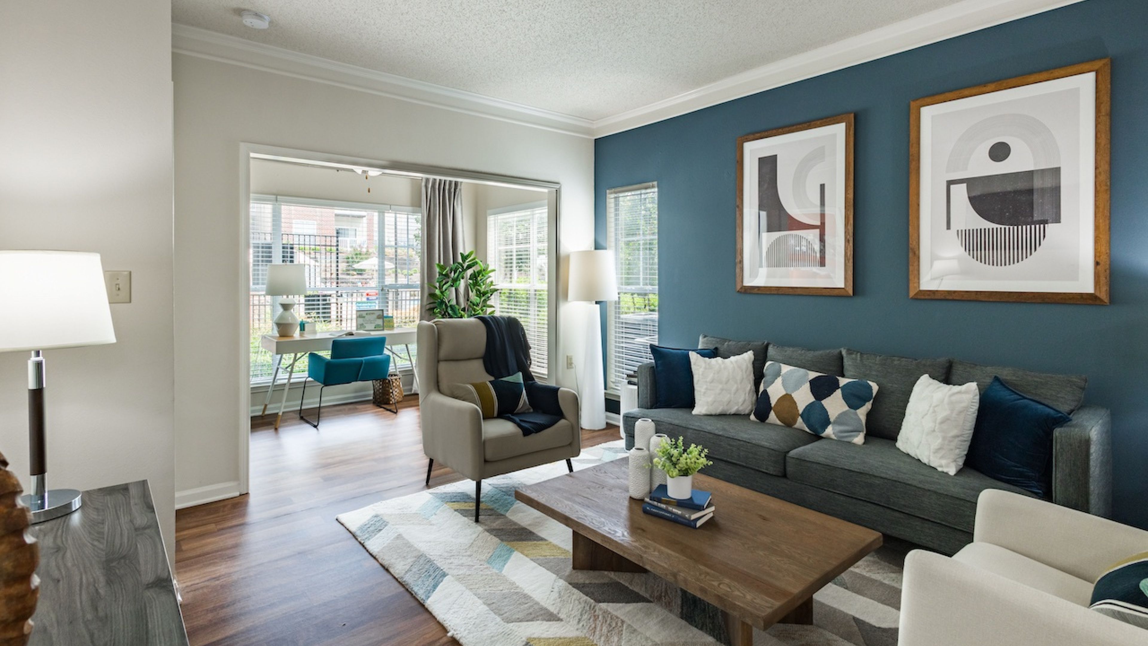Hawthorne at Main apartment living room with large windows, furnished with a couch, coffee table, and chairs