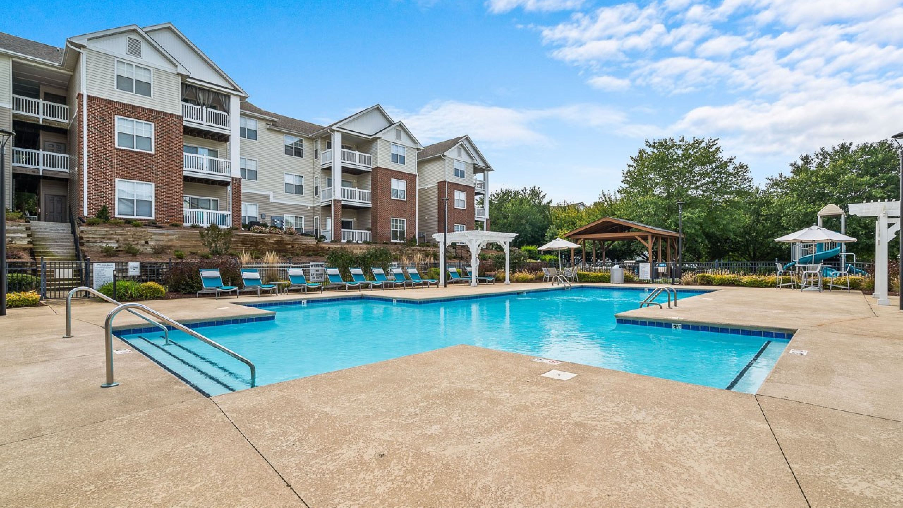 Hawthorne at Main large outdoor pool with surrounding seating, umbrellas, and grilling area